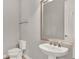 Neutral half-bathroom featuring a pedestal sink, large mirror, and modern fixtures at 2505 Civitas Pl, Casselberry, FL 32707