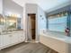 Bright bathroom featuring a soaking tub, marble countertop vanity, and walk-in shower at 25110 Meriweather Rd, Leesburg, FL 34748