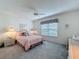 Bedroom features a ceiling fan, carpeted floor, and window at 25110 Meriweather Rd, Leesburg, FL 34748