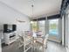 Bright dining area featuring a glass-top table, seating for four, and view of the lanai and pool at 25110 Meriweather Rd, Leesburg, FL 34748