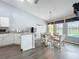 Bright dining area with view of lanai and pool, with nearby kitchen featuring white cabinets and granite counters at 25110 Meriweather Rd, Leesburg, FL 34748