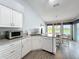 Well-lit kitchen with white cabinetry, granite counters, stainless appliances, and open access to the dining area at 25110 Meriweather Rd, Leesburg, FL 34748