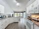 Bright kitchen with white cabinets, granite countertops, stainless appliances, and a view of the dining area at 25110 Meriweather Rd, Leesburg, FL 34748