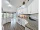 Bright kitchen with white cabinets, granite countertops, and modern appliances overlooking a pool at 25110 Meriweather Rd, Leesburg, FL 34748