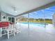 Screened lanai with ceiling fan looks out onto an outdoor pool and green space at 25110 Meriweather Rd, Leesburg, FL 34748