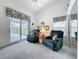 Living room features vaulted ceiling, ceiling fan, plush chairs, and access to a screened in patio at 25110 Meriweather Rd, Leesburg, FL 34748