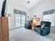 Living room features vaulted ceiling, ceiling fan, plush chairs, and access to a screened in patio at 25110 Meriweather Rd, Leesburg, FL 34748