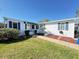 Inviting front exterior with a well-maintained lawn and blue shutters at 25447 Belle Alliance, Leesburg, FL 34748