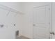 Laundry room featuring a white door, wood-look tile and wire rack shelving at 2824 Supermarine Rd, Tavares, FL 32778