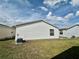 Backyard view showing the side of the home, lawn and neighboring house at 2910 Barboza Dr, The Villages, FL 32162