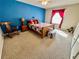 Comfortable bedroom with blue accent wall, window, and bedside table at 2910 Barboza Dr, The Villages, FL 32162