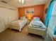 Comfortable bedroom with matching twin beds, colorful accent wall, and sliding closet doors at 2910 Barboza Dr, The Villages, FL 32162