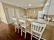 The breakfast bar features white chairs, opening to the eating area and the kitchen at 2910 Barboza Dr, The Villages, FL 32162