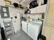Functional laundry room with washer, dryer, and ample storage space on shelves at 2910 Barboza Dr, The Villages, FL 32162