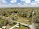 Aerial view of lush acreage with long ranch home and private pond, close to road at 2930 Cr 416N, Lake Panasoffkee, FL 33538