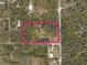 Aerial view of the property, surrounded by lush trees and featuring a pond; outlined in pink at 2930 Cr 416N, Lake Panasoffkee, FL 33538