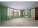 Spacious bedroom with light green walls, carpeted floors, and large windows with mirrored closet doors at 2930 Cr 416N, Lake Panasoffkee, FL 33538