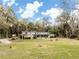 Exterior home view shows the yard and trees surrounding the beautiful acreage at 2930 Cr 416N, Lake Panasoffkee, FL 33538