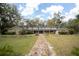 Two-story home featuring a symmetrical design, brick accents, and lush landscaping at 2930 Cr 416N, Lake Panasoffkee, FL 33538