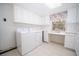 Bright laundry room equipped with modern washer and dryer, cabinetry and a workstation at 2930 Cr 416N, Lake Panasoffkee, FL 33538