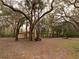 Outbuilding with covered carport area, surrounded by mature trees and foliage at 2930 Cr 416N, Lake Panasoffkee, FL 33538