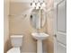 Bright half bathroom featuring a pedestal sink and decorative mirror and modern fixtures at 30342 Gidran Ter, Mount Dora, FL 32757