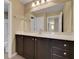 Bathroom vanity with dark cabinets, quartz countertop, and large mirror offering lots of light at 30342 Gidran Ter, Mount Dora, FL 32757