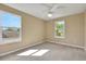This is a carpeted bedroom with two bright windows and a ceiling fan at 30342 Gidran Ter, Mount Dora, FL 32757