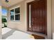A welcoming front entrance with a handsome brown door, glass, and a window providing natural light to the home's entry at 30342 Gidran Ter, Mount Dora, FL 32757