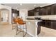 Open kitchen with dark cabinets, granite countertops, stainless steel appliances and a kitchen island at 30342 Gidran Ter, Mount Dora, FL 32757