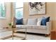 Bright living room featuring modern sofa, coffee table, and natural light from large windows at 30342 Gidran Ter, Mount Dora, FL 32757