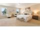Spacious main bedroom with two windows, neutral decor, sitting area and a king size bed at 30342 Gidran Ter, Mount Dora, FL 32757