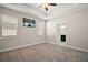 Spacious bedroom featuring a ceiling fan, two windows, and neutral carpet at 3139 Hurston Watch Ln, Clermont, FL 34711