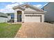 Charming single-story home with a well-manicured lawn, brick driveway, and a two-car garage, offering curb appeal at 3139 Hurston Watch Ln, Clermont, FL 34711