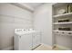 Well-lit laundry room with a washer, dryer, wire shelving, and built-in shelves for added storage and convenience at 3139 Hurston Watch Ln, Clermont, FL 34711