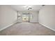 Bright and airy living room featuring carpet, a ceiling fan and sliding door access to the backyard at 3139 Hurston Watch Ln, Clermont, FL 34711