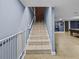 Basement stairs leading down to a finished space with tile floors and lots of room to entertain at 31400 Saunders Dr, Tavares, FL 32778