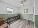 Spacious bedroom with wood-look floors, a ceiling fan, and two windows for ample natural light at 31400 Saunders Dr, Tavares, FL 32778