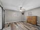 Bedroom with wood-look floors and barn door access at 31400 Saunders Dr, Tavares, FL 32778