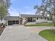 Charming single-story home with brick exterior, front porch, and a spacious driveway with attached garage at 31400 Saunders Dr, Tavares, FL 32778