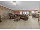 Spacious living room featuring a brick accent wall, tile flooring, and an open layout concept at 31400 Saunders Dr, Tavares, FL 32778