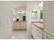 Bathroom boasting dual sinks with corian countertops, framed mirrors and a tiled floor at 3144 Mayflower Loop, The Villages, FL 32163