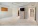 Bright bedroom features an entertainment center, closet access, and doorway to a hallway at 3144 Mayflower Loop, The Villages, FL 32163