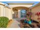 Charming front entrance with decorative door, arched window, complemented by colorful plants and a welcoming walkway at 3144 Mayflower Loop, The Villages, FL 32163