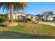 Beautiful single-story home with a lush green lawn, mature palm trees, and meticulous landscaping, creating curb appeal at 3144 Mayflower Loop, The Villages, FL 32163