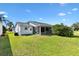 The backyard has a screened in lanai, well-maintained lawn, and privacy landscaping at 3349 Ashbrook Pl, The Villages, FL 32162