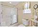 Bright bathroom features a tiled shower with glass doors, toilet, and window at 3349 Ashbrook Pl, The Villages, FL 32162