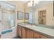 Bright bathroom features a vanity with sink, tile flooring, and a shower/tub combo at 3349 Ashbrook Pl, The Villages, FL 32162