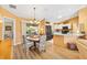 Dining area featuring a round wooden table, wicker chairs, sliding glass doors, and a view of the kitchen at 3349 Ashbrook Pl, The Villages, FL 32162