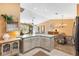 Open kitchen featuring an island, white cabinets, light countertops, and a view to the dining and living areas at 3349 Ashbrook Pl, The Villages, FL 32162
